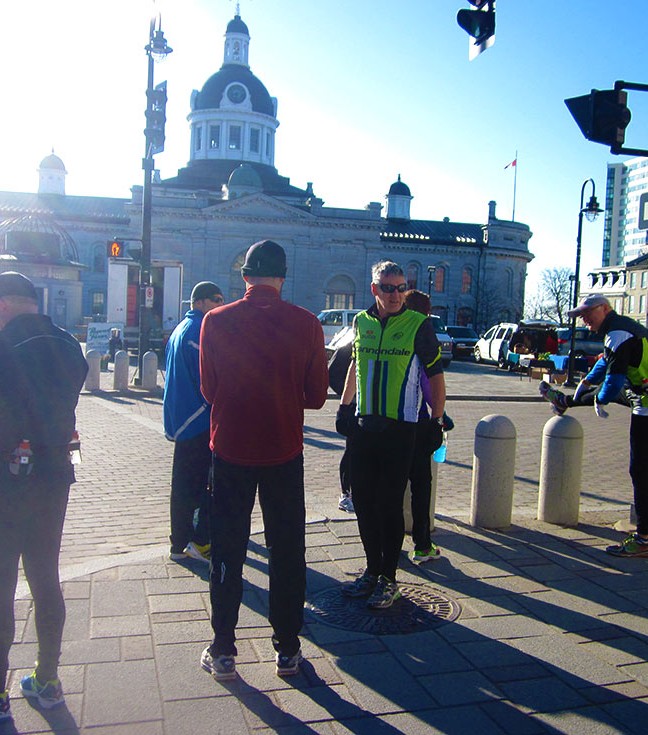 Runners have left Runners Choice for their Sunday morning run. After locking up, Al heads out with his group. They will quickly pass those who started earlier.