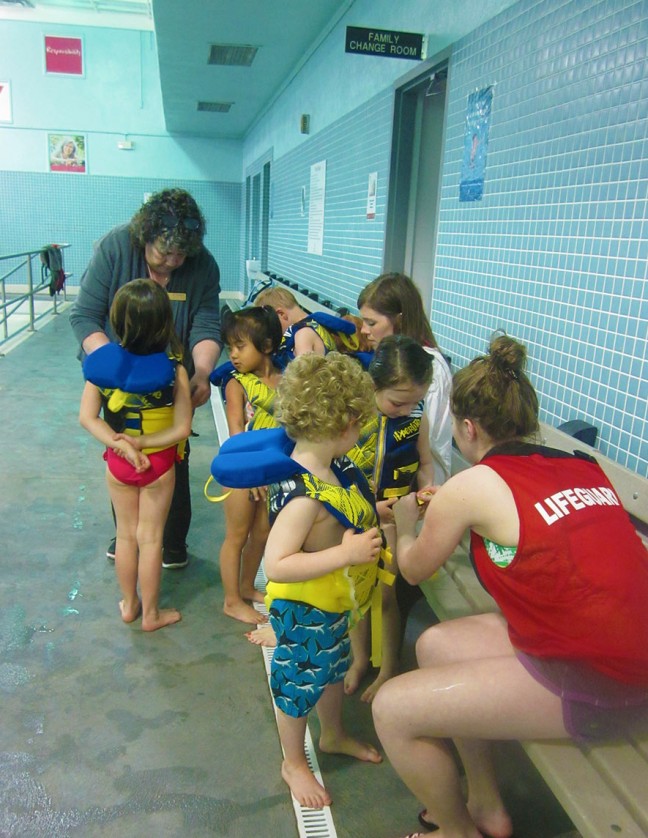 All hands are on deck to help with life jackets.