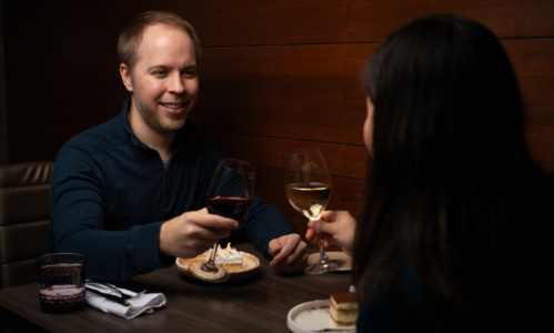 Two people enjoying wine at Aquaterra as they sit in front of each other.
