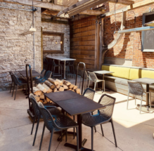 Outdoor tables and seating at Wooden Heads Gourmet Pizza's courtyard patio