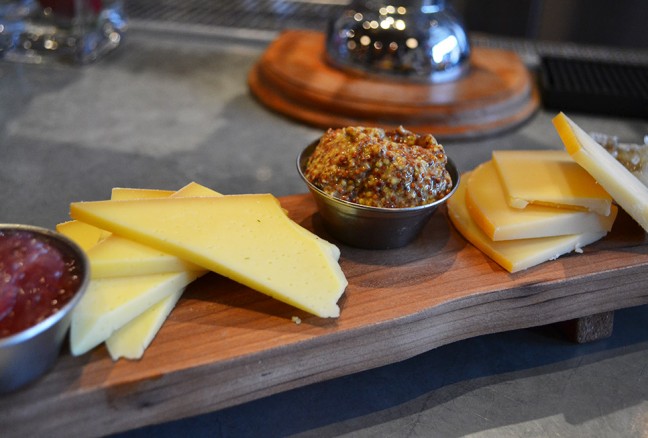 Charcuterie board from Le Chien Noir Bistro with two cheese options and cured meat.