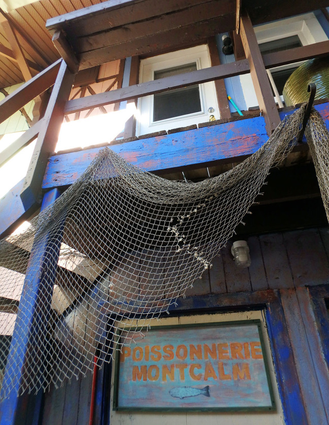 Hung over the banister is a fishing net, and underneath it, a sign that playfully suggests we are in a French city.