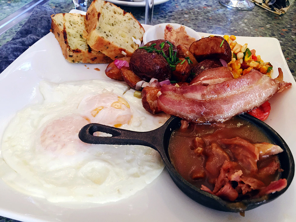 Pan Chancho's El Chancho – bacon, chorizo, over easy eggs, roasted corn salad, lemon and thyme potatoes, caramelized onions, campfire gravy, grilled savoury brioche and bacon jam.