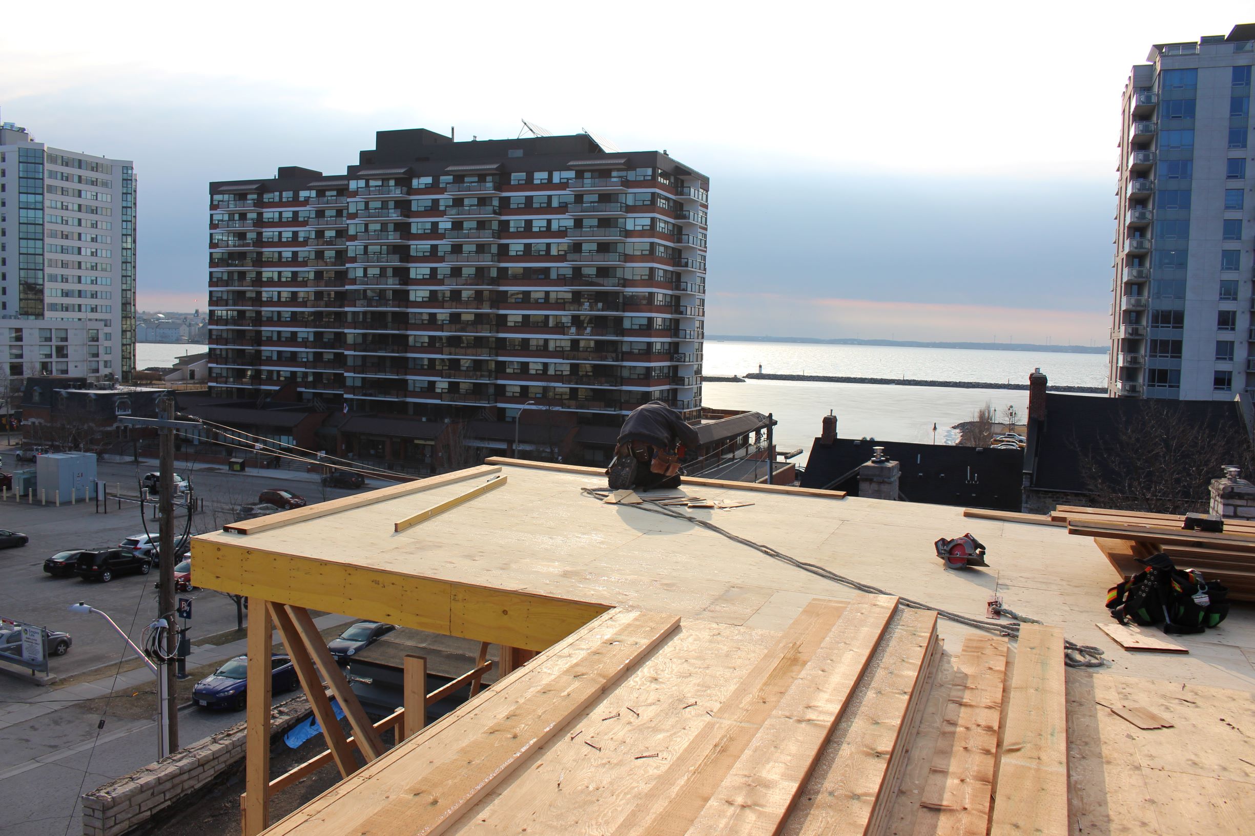 construction worker on rooftop overlooking Lake Ontario
