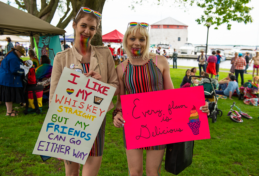 Two women holding signs at the community fair