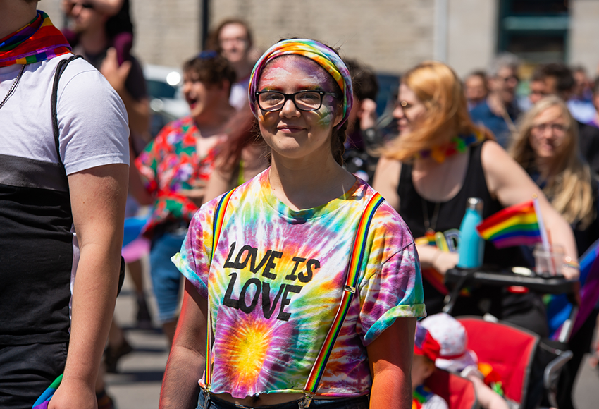 Portrait of a young woman in rainbow tie-dye and suspenders
