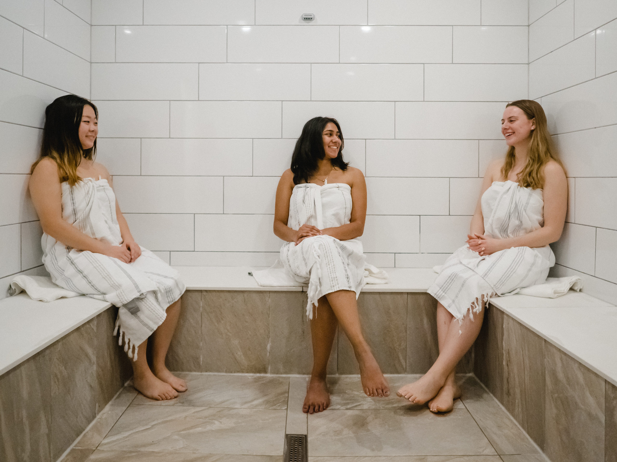 Three people sitting in a towels at Refinery Spa and Social House