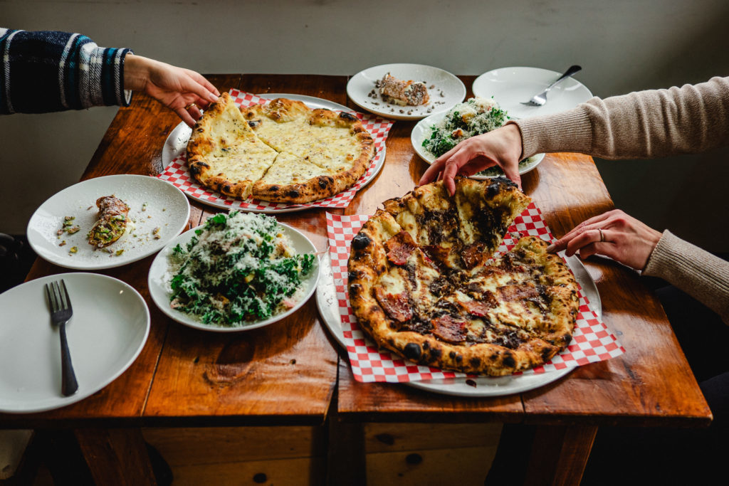 pizza, salad, and cannoli's on a table at Pizza Monster 