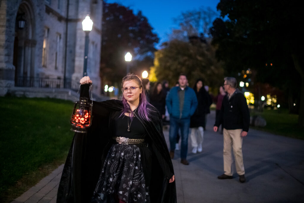 People following the Haunted Walk guide holding lantern 