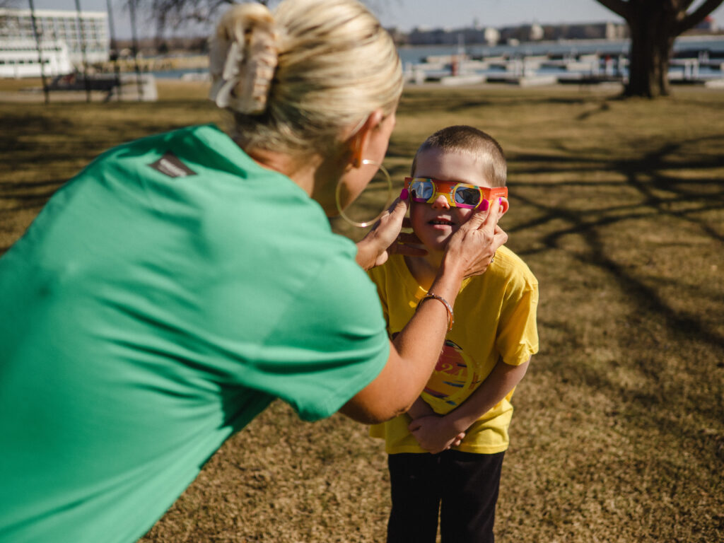 Mother putting on Kid's eclipse glasses